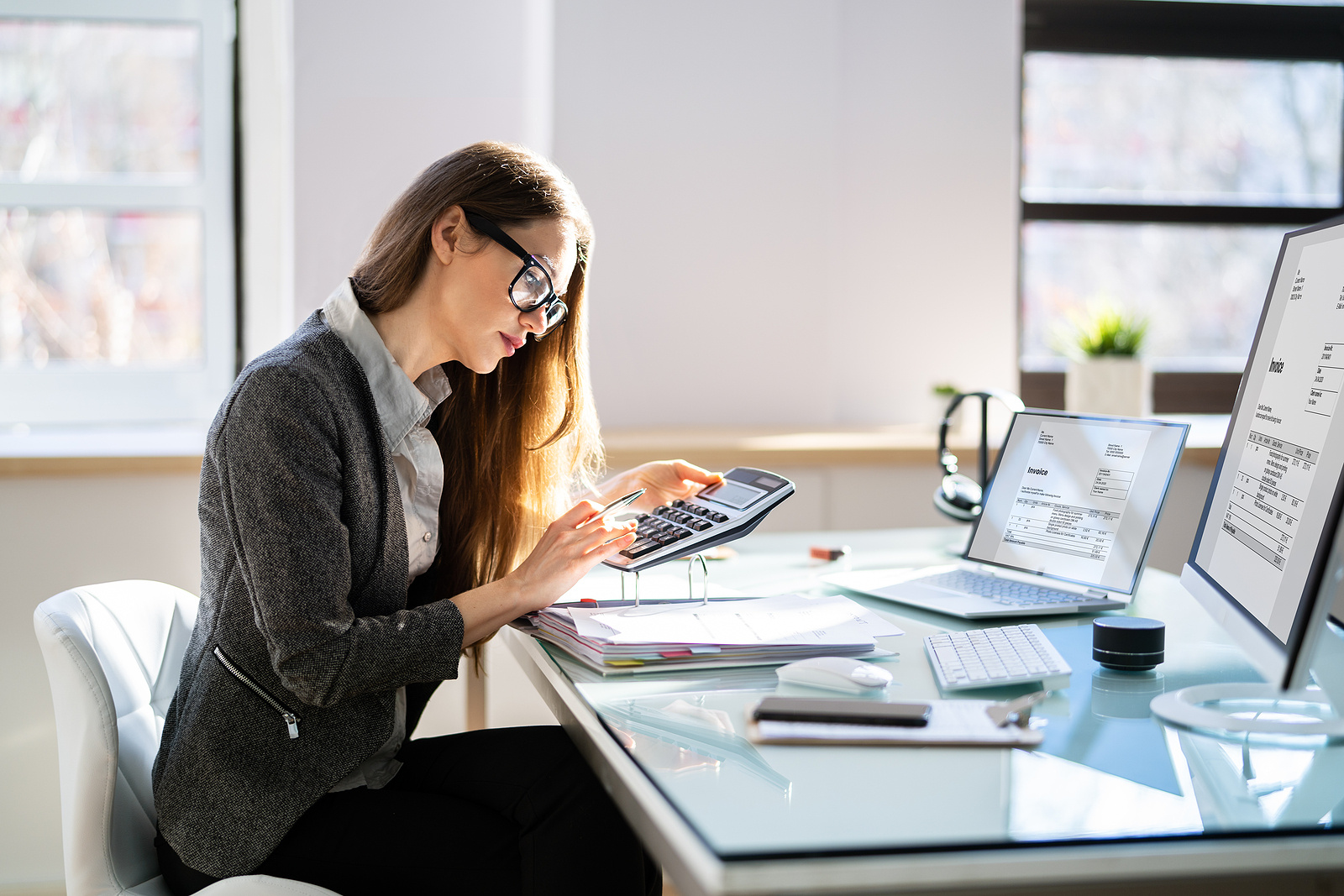 Woman working holding calculator at Gurian CPA Firm in Dallas, Texas