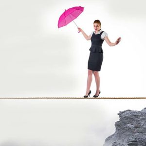 A woman accountant holding a pink umbrella is tight rope walking
